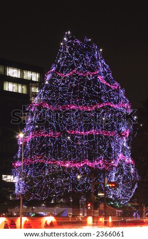 Festive decorated tree during a street illumination festival in Sendai.In the bottom of the image there is a motion blur generated by the traffic.