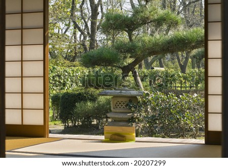Japanese garden seen through a traditional sliding wall of a wooden house.