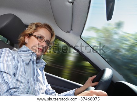 Image of a businesswoman driving a car.