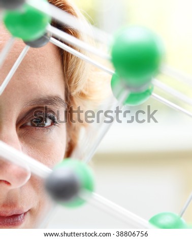 Image of a female researcher eye through a molecular model structure.Selective focus on the eye.