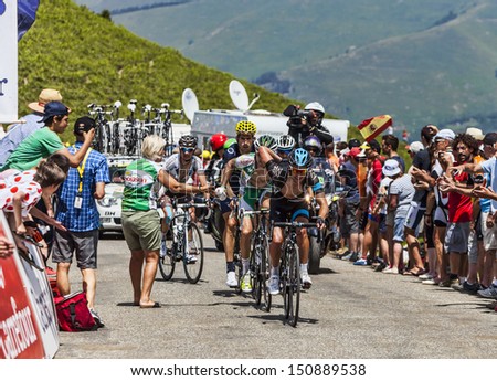VAL LOURON, FRANCE - JUL 7: Cyclists lead by Richie Porte (Sky Procycling Team) receiving water flasks while  passing the Col de Val Lauron-Azet during the stage 9 of  Le Tour de France on July 7 2013.