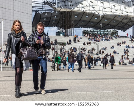 PARIS,APRIL 19:Unidentified couple walking in the major business district, La Defense,in the western part of Paris, France on April 19 2012. Here are many of the Paris urban area\'s tallest high-rises.