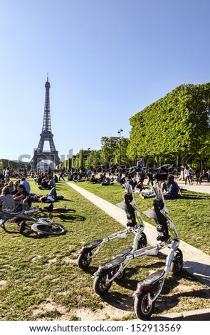 PARIS- MAY 13: Modern electric Trikke vehicles parked on Champ de Mars in front of the Eiffel Tower on May 13, 2012. Eiffel Tower is the most popular French touristic attraction.