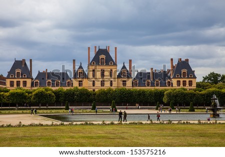 FONTAINEBLEAU,FRANCE- JUN 19:People walking in a courtyard located in front of a part of The Palace of Fontainebleau,one of the largest royal palace in France, on 19 June, 2011 in Fontainebleau.