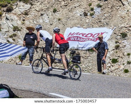 PORT DE PAILHERES,FRANCE- JUL 6:Amateur cyclist couple on a tandem bicycle climbs the road to the Col de Pailheres before the apparition of the peloton in the stage 8 Le Tour de France on 6 July  2013
