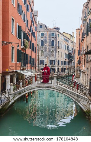 VENICE-FEB 19:Image of a man disguised as a Roman character on a small bridge over a channel on February 19, 2012 in Venice.In 2014 the Venice Carnival will be between February 15- March 4