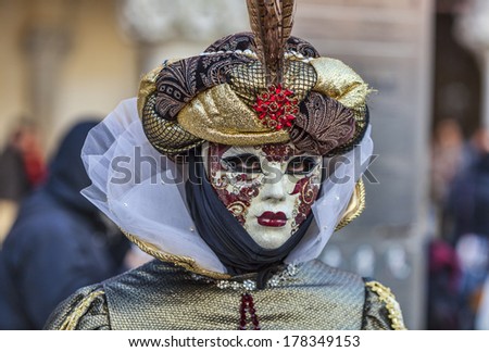 VENICE-FEB 18:Portrait of a person in a Venetian mask with pheasant feathers in San Marco Square on February 18, 2012 in Venice.In 2014 the Venice Carnival is between February 15- March 4