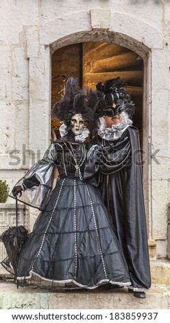 ANNECY, FRANCE,MAR 15:A couple disguised poses at the entrance in a building in Annecy,France,on March 15 2014.Every year here is held a Venetian Carnival to celebrate the beauty of real Venice