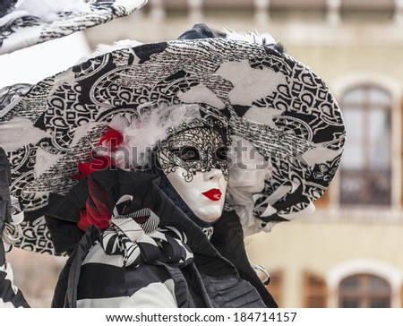 ANNECY,FRANCE,MAR 15:Portrait of a person in a mask with a big hat posing in Annecy,France,on March 15 2014.Every year here is held a Venetian Carnival to celebrate the beauty of real Venice