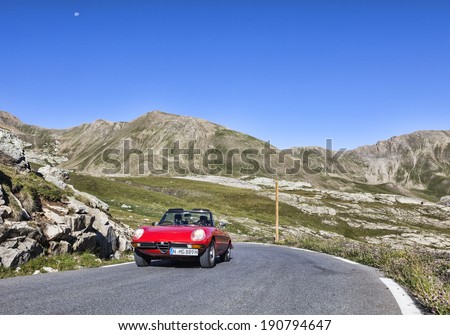 ROUTE DE NICE,FRANCE-AUGUST 25:Red vintage Alfa Romeo car driving on the road from Jausiers to Cime de la Bonette, the highest asphalted road in Europe on August 25,2013.