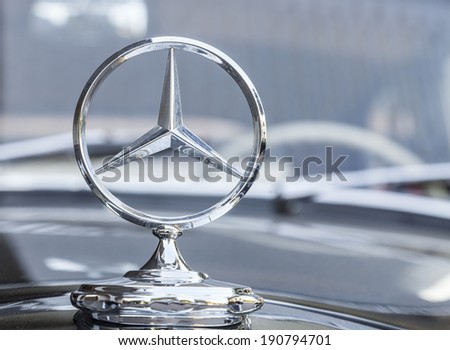STUTTGART,GERMANY- AUG 11:Mercedes logo on a traditional car in front of an elegant hotel in Stuttgart,Germany on August 11, 2013.In Stuttgart is the headquarter of Mercedens-Benz.
