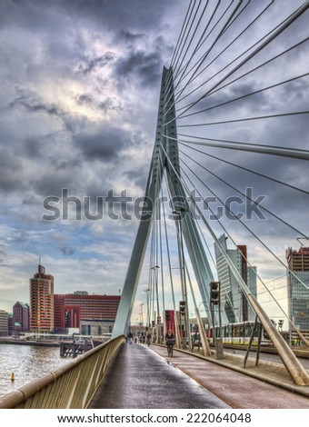 ROTTERDAM,NETHERLANDS- APR 24:Image of few people cycling on the Erasmus Bridge during a rainy day on April 24, 2012 in Rotterdam.This bridge links the northern and southern regions of the city