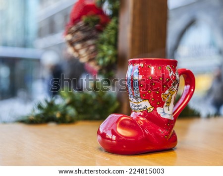 MUNICH,GERMANY- DEC 19:A wine cup in shape of a boot is on a wooden desk outside, during a traditional Christmas market in Munich,Germany on 19 December 2014. Such cups are used to drink hot wine.