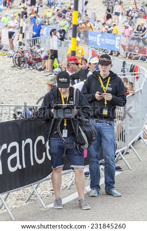 LE MONT VENTOUX, FRANCE-JUL 14:Two young men using modern electronic devices to transmit data from the road to Mont Ventoux during the stage 15 of Le Tour de France on July 14 2013.