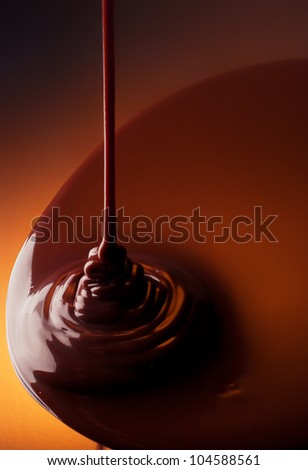 Chocolate pouring on a reflective surface
