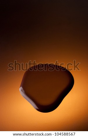 Chocolate puddle on reflective surface