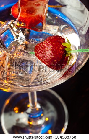 Closeup of strawberries and ice cubes in martini glass