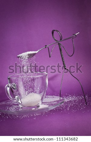 Wire character shoveling white sugar into empty glass cup
