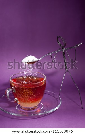 Wire character shoveling white sugar into tea cup