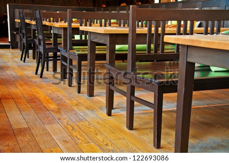 Small restaurant interiour with wooden floor and furniture