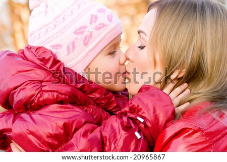 Mother and little daughter kissing