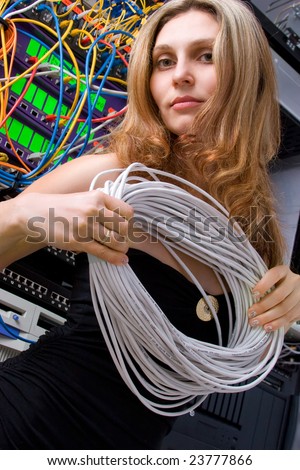 Attractive young model against servers with cable in hands