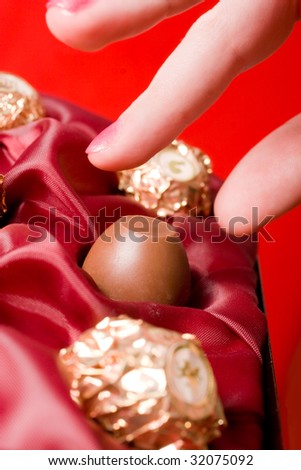 Fingers picking up chocolate candies