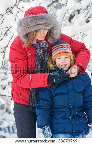 Mother playing with son in winter forest