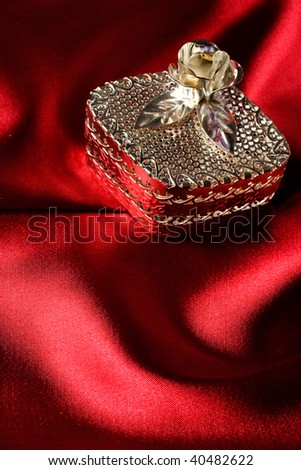Silver jewel case over wavy silk background