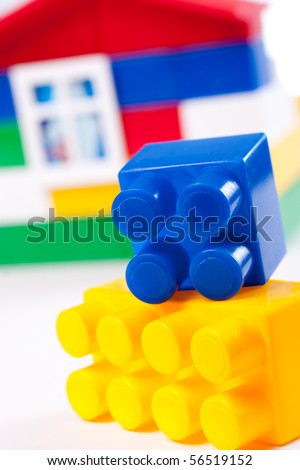 Toy house build with colorful plastic blocks isolated on white