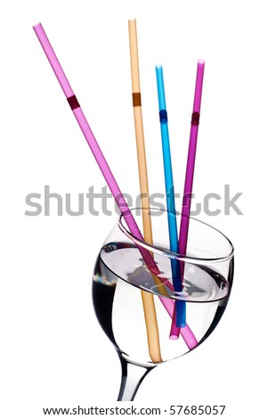 Multicolored straws in glass with clear liquid