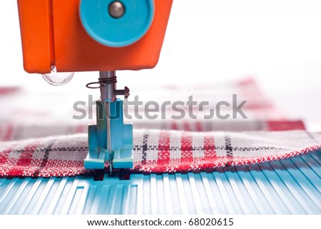 Closeup of sewing machine working part with red cloth