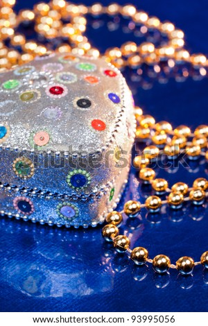 Jewel box and golden beads on blue background