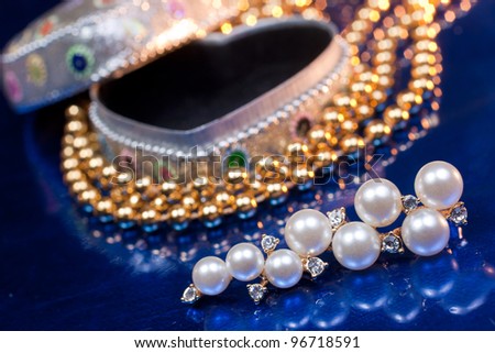 Open heart shaped jewel box with pearl earring and golden beads