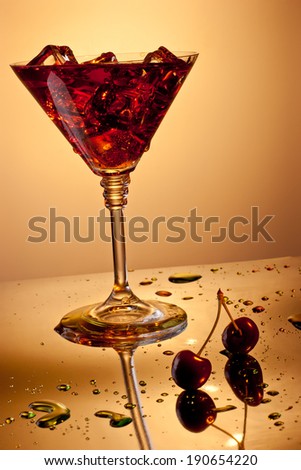 Martini glass with ice cubes and cherries