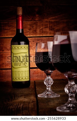 Wine bottle with self made label  and glasses filled with wine on wooden table