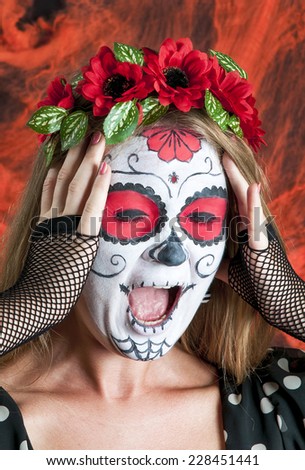 Portrait of young blond girl in black dress with Calavera Mexicana makeup mask with emotions of horror on her face