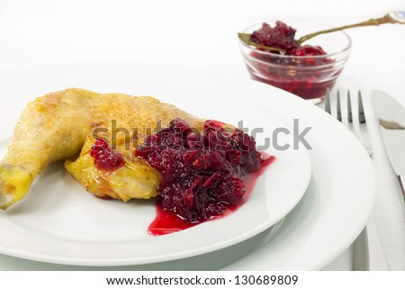 Roast chicken with cranberry sauce on a white plate