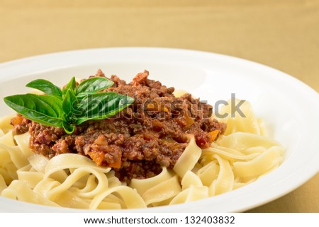 Spaghetti with tomato beef sauce topped with basil
