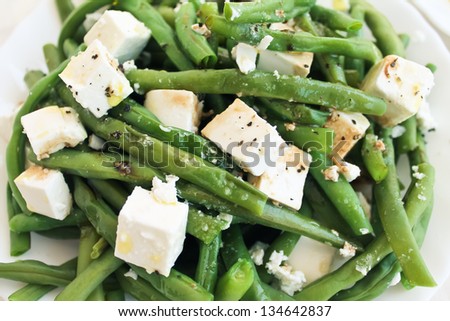 Green beans salad with feta on a white plate