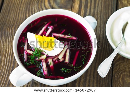 Cold vegetable soup with beetroot and  cucumber topped with egg and dill