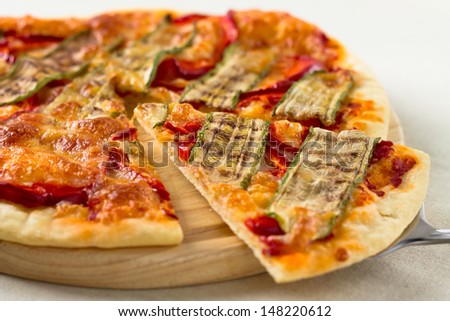 Italian vegetarian pizza lifted slice with pepper and zucchini