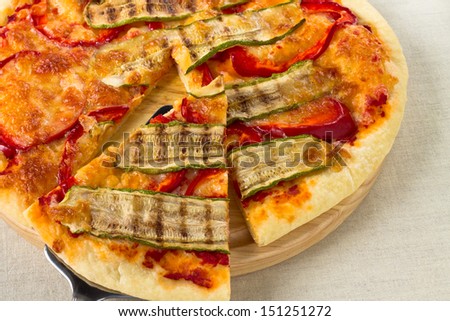 Italian vegetarian pizza lifted slice with pepper and zucchini