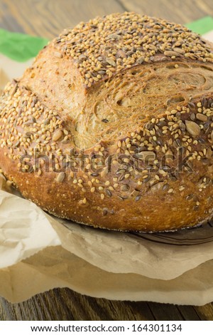 Whole wheat bread on a paper bag on wooden background