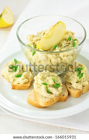 Creamy pate served with french bread and a bowl of pate topped with apple