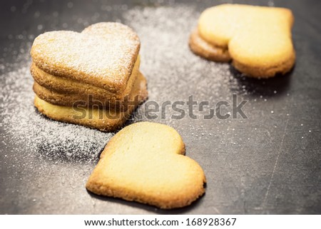 Shortbread cookies in shape of heart as symbol of love over gray background
