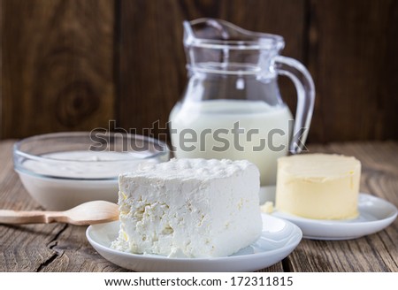Dairy milk products: cheese, milk,  sour cream,  butter on rustic wooden background