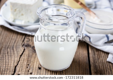Dairy milk products. A milk jug on wooden board