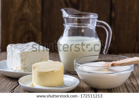 Dairy milk products: cheese, milk,  sour cream,  butter on rustic wooden background