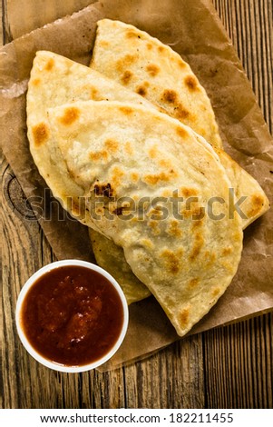 Homemade flatbread with meat, cheese, and salsa viewed from above. Yantyk - traditional Crimean tatar flat bread